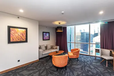 a living room with a couch and a table and chairs at Park Regis Business Bay in Dubai