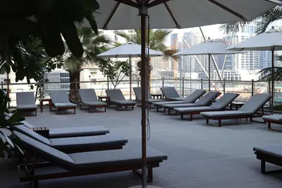 a group of lounge chairs and umbrellas on a building at Park Regis Business Bay in Dubai
