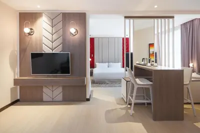 a hotel room with a television and a bedroom at Barcelo Al Jaddaf, Dubai in Dubai