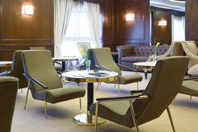 a waiting room with tables and chairs at Barcelo Al Jaddaf, Dubai in Dubai