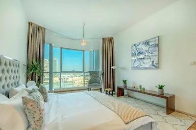 a bedroom with a bed and a large window at AUBERGE Luxury 2BR Full Burj Khalifa and Fountain View in Dubai
