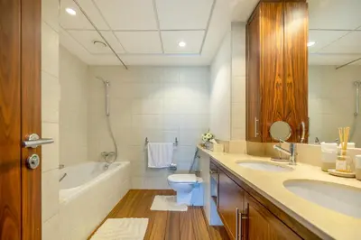 a bathroom with a tub and a toilet and a sink at AUBERGE Luxury 2BR Full Burj Khalifa and Fountain View in Dubai