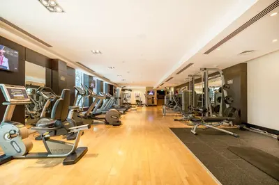 a gym with treadmills and elliptical machines at AUBERGE Luxury 2BR Full Burj Khalifa and Fountain View in Dubai