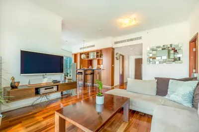a living room with a couch and a tv at AUBERGE Luxury 2BR Full Burj Khalifa and Fountain View in Dubai