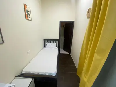a small room with a bed and a yellow curtain at Nice Single Rooms for 