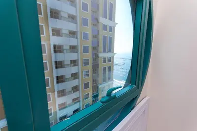 a window with a view of a tall building at Nice Single Rooms for 