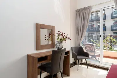 a room with a desk with two chairs and a mirror at BLVD - Spacious Fully Equipped Luxury Residences - Dubai - JVC in Dubai