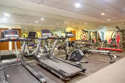 a gym with a bunch of treadmills and machines at BLVD - Spacious Fully Equipped Luxury Residences - Dubai - JVC in Dubai