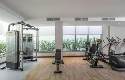 a gym with treadmills and ellipticals in a room with windows at Hampton By Hilton Dubai Al Barsha in Dubai