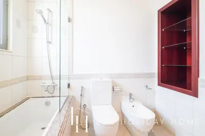 a bathroom with a toilet and a tub and a sink at LUX - The Ocean Pearl Villa in Dubai