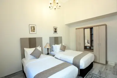 two beds in a room with white walls at Marbella Holiday Homes in Dubai