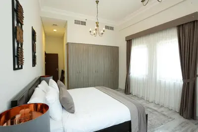 a bedroom with a white bed and a window at Marbella Holiday Homes in Dubai