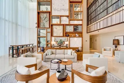 a living room with white furniture and a large wall of windows at Vida Downtown Residences in Dubai