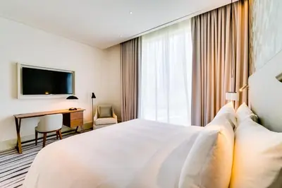 a hotel room with a white bed and a desk at Vida Downtown Residences in Dubai