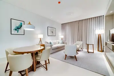 a living room with a table and chairs and a couch at Vida Downtown Residences in Dubai