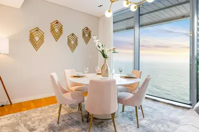 a dining room with a table and chairs and a large window at FAM Living Bluewaters - Island Living - Ain Dubai & Sea View in Dubai
