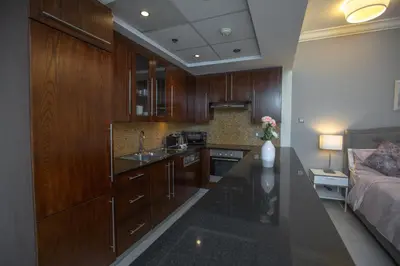 a kitchen with wooden cabinets and a counter top at Prime Retreats - Downtown Dubai in Dubai