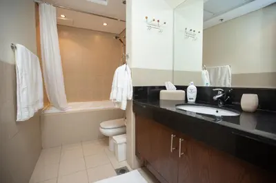 a bathroom with a sink and a toilet and a mirror at Prime Retreats - Downtown Dubai in Dubai