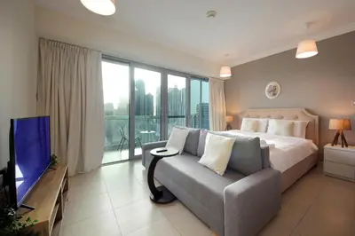 a bedroom with a bed and a couch and a tv at Prime Retreats- Downtown Dubai in Dubai