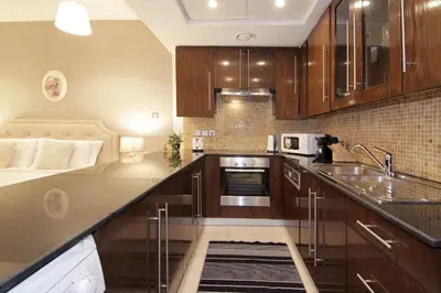 a kitchen with wooden cabinets and a counter top at Prime Retreats- Downtown Dubai in Dubai