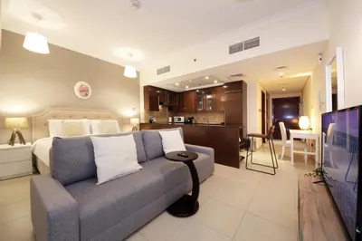 a bedroom with a bed and a couch and a kitchen at Prime Retreats- Downtown Dubai in Dubai