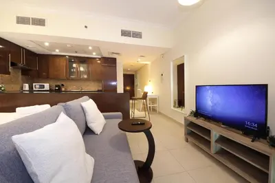 a living room with a couch and a flat screen tv at Prime Retreats- Downtown Dubai in Dubai