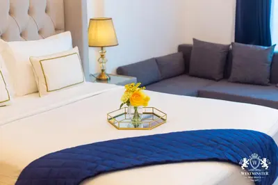 a hotel room with a bed with a vase with flowers on it at Westminster Claren Tower - Downtown in Dubai
