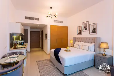 a bedroom with a large bed and a kitchen at Westminster Claren Tower - Downtown in Dubai