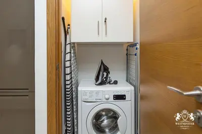 a washer and dryer in a kitchen next to a door at Westminster Claren Tower - Downtown in Dubai