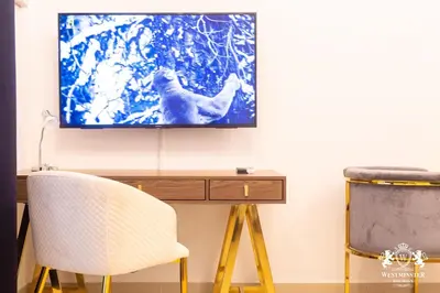 a tv sitting on a wall above a desk with a chair at Westminster Claren Tower - Downtown in Dubai