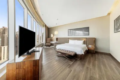 a hotel room with a bed and a flat screen tv at Radisson Blu Hotel, Dubai Canal View in Dubai