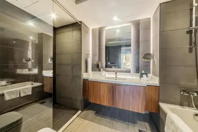 a bathroom with two sinks and a tub and a mirror at Radisson Blu Hotel, Dubai Canal View in Dubai