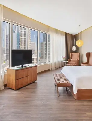 a hotel room with a bed and a flat screen tv at Radisson Blu Hotel, Dubai Canal View in Dubai
