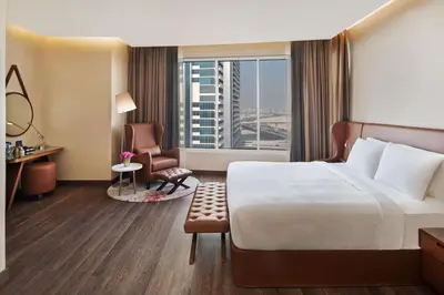 a hotel room with a bed and a large window at Radisson Blu Hotel, Dubai Canal View in Dubai