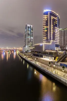 a city with tall buildings and a river at night at Radisson Blu Hotel, Dubai Canal View in Dubai