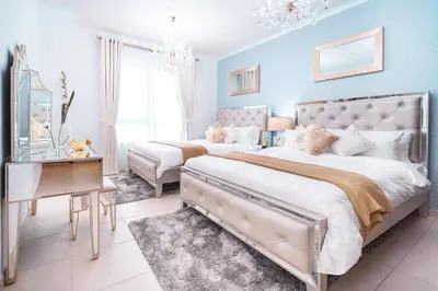 a blue bedroom with two beds and a table at Elite Royal Apartment - Full Burj Khalifa & Fountain View - Deluxe in Dubai