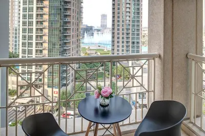 a table with a vase of flowers on a balcony at Bella Vista - 29 Boulevard Downtown Burj Khalifa in Dubai