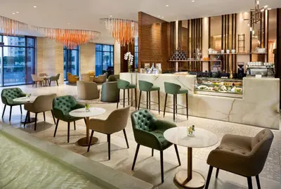 a restaurant with tables and chairs and a bar at Millennium Place Barsha Heights Hotel Apartments in Dubai