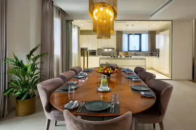 a large wooden table with chairs and a large kitchen at Millennium Place Barsha Heights Hotel Apartments in Dubai