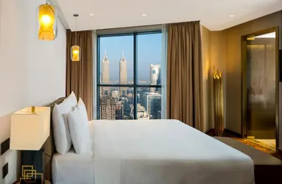 a hotel room with a large bed and a large window at Millennium Place Barsha Heights Hotel Apartments in Dubai
