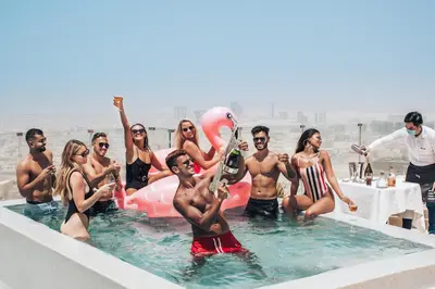 a group of people in the water at a pool at FIVE Jumeirah Village in Dubai