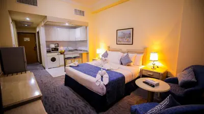a hotel room with a bed and a kitchen at Green House Hotel Suites & Apartment in Dubai