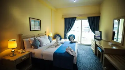 a hotel room with a bed with towels on it at Green House Hotel Suites & Apartment in Dubai