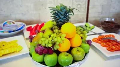 a bowl of fruits and vegetables on a table at Green House Hotel Suites & Apartment in Dubai