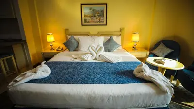 a bedroom with a large bed with towels on it at Green House Hotel Suites & Apartment in Dubai