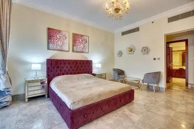 a bedroom with a large bed and a chandelier at South & North Residence Palm Jumeirah in Dubai