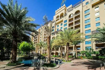 a large building with palm trees in front of it at South & North Residence Palm Jumeirah in Dubai