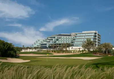 a golf course with a hotel in the background at JA Lake View Hotel, Dubai in Dubai