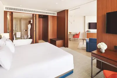 a hotel room with a white bed and a television at JA Lake View Hotel, Dubai in Dubai