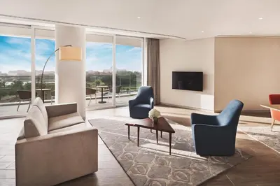 a living room with a couch and chairs and a tv at JA Lake View Hotel, Dubai in Dubai